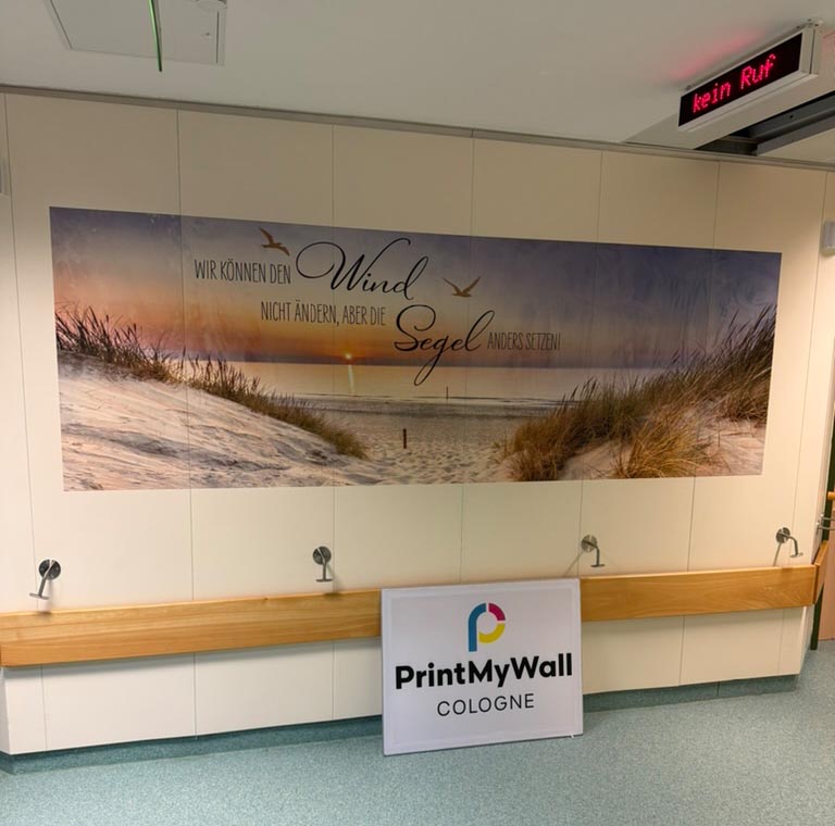 Großformatiger Wanddruck mit Strandmotiv und Zitat auf einer Palliativstation in einem Krankenhaus